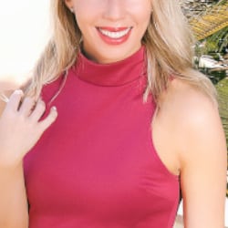 Celine - Escort Agentur Frankfurt Model im roten Kleid mit einem breiten Lächeln.