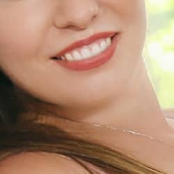 Sophia- VIP Escortmodel Berlin mit roten Lippen und einem breiten Lächeln.