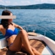 Gina - Escortmodel Köln im blauen Bikini auf einem Boot sitzend.