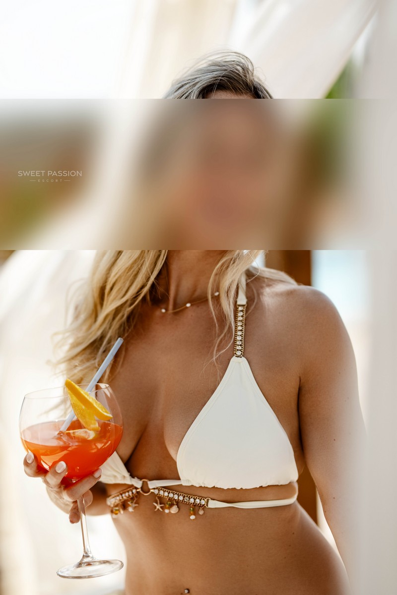 isabella – schlankes escort duesseldorf isabella - schlankes escort duesseldorf im weissen Bikini mit Cocktail in der Hand. Ihre Haut ist sonnengebräunt und ihre langen blonden Haare fallen über ihre Schulter.