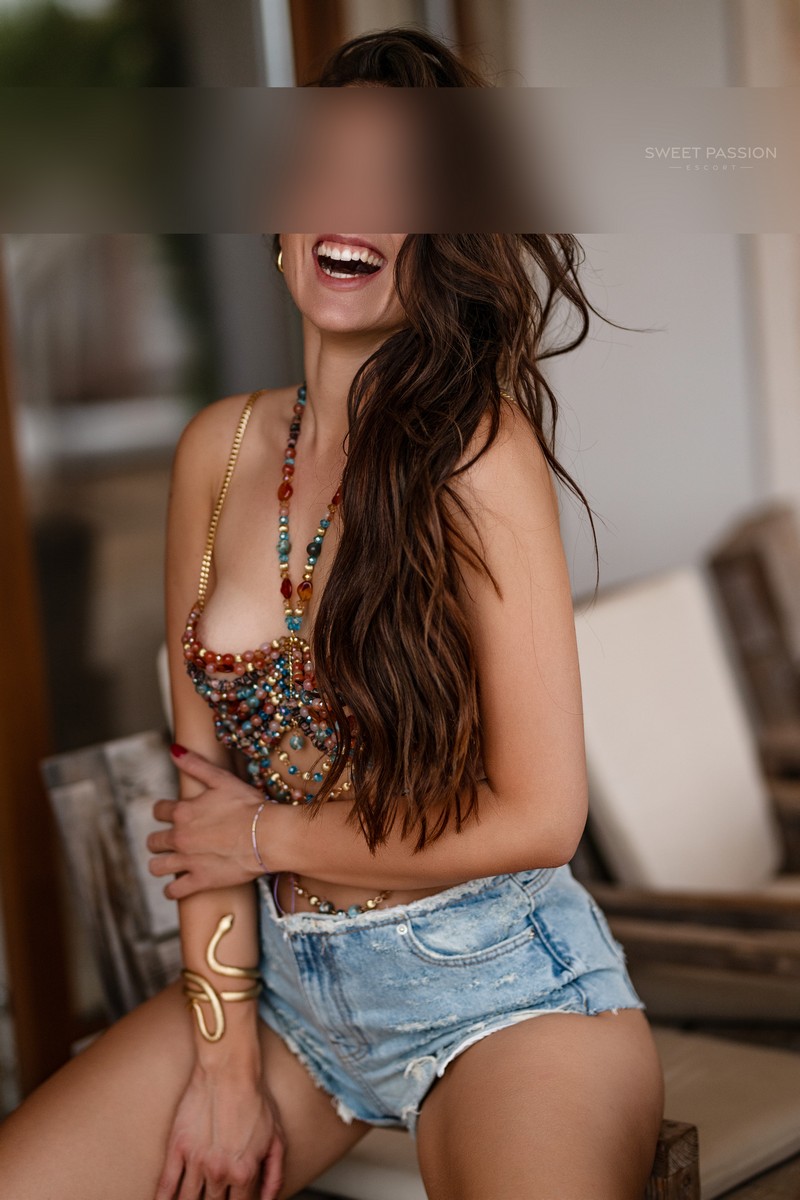 alina - natuerliches escort hamburg, bunter Perlen-BH, kurze Jeans-shorts, tolles Lachen, gold Armreif,